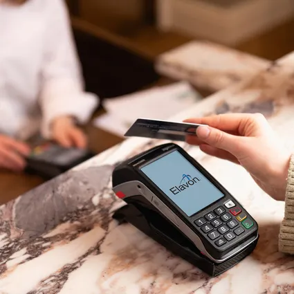 Kontaktloses bezahlen mit smartwatch, lächelnde kassiererin reicht kartenlesegerät, modernes kassensystem