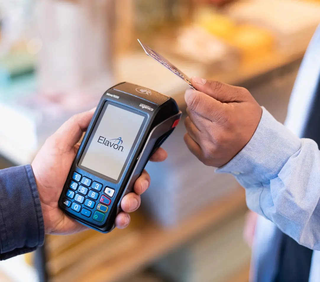 Eine hand hält ein portables zahlungsterminal während eine andere hand eine kreditkarte für kontaktlose zahlung hält