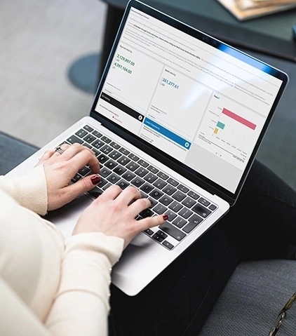 Person tippt auf einem laptop der grafiken und datendiagramme auf dem bildschirm anzeigt