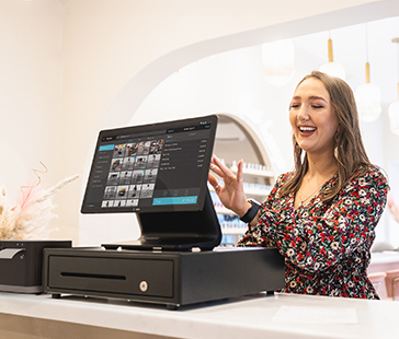 Person bedient ein touchscreen kassensystem auf einer theke in einer einzelhandelsumgebung